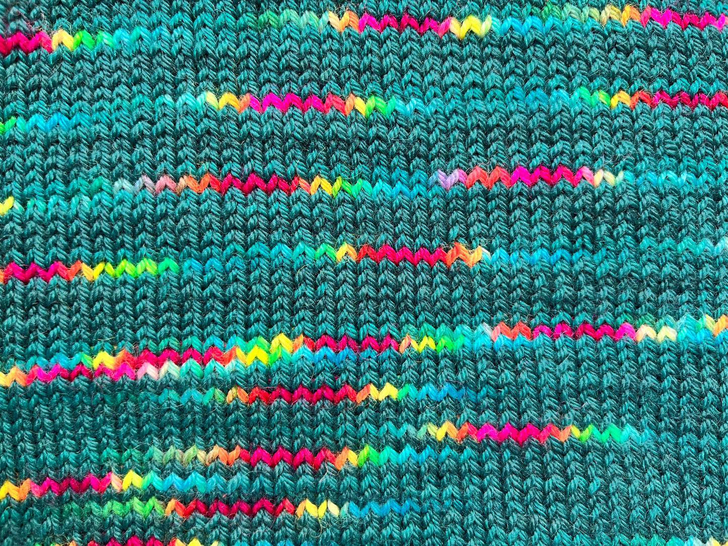 Close up of knitted yarn in Frida Kahlo yarn from the BFL DK Wool collection by the hand dyed yarn expert, The Wool Kitchen.