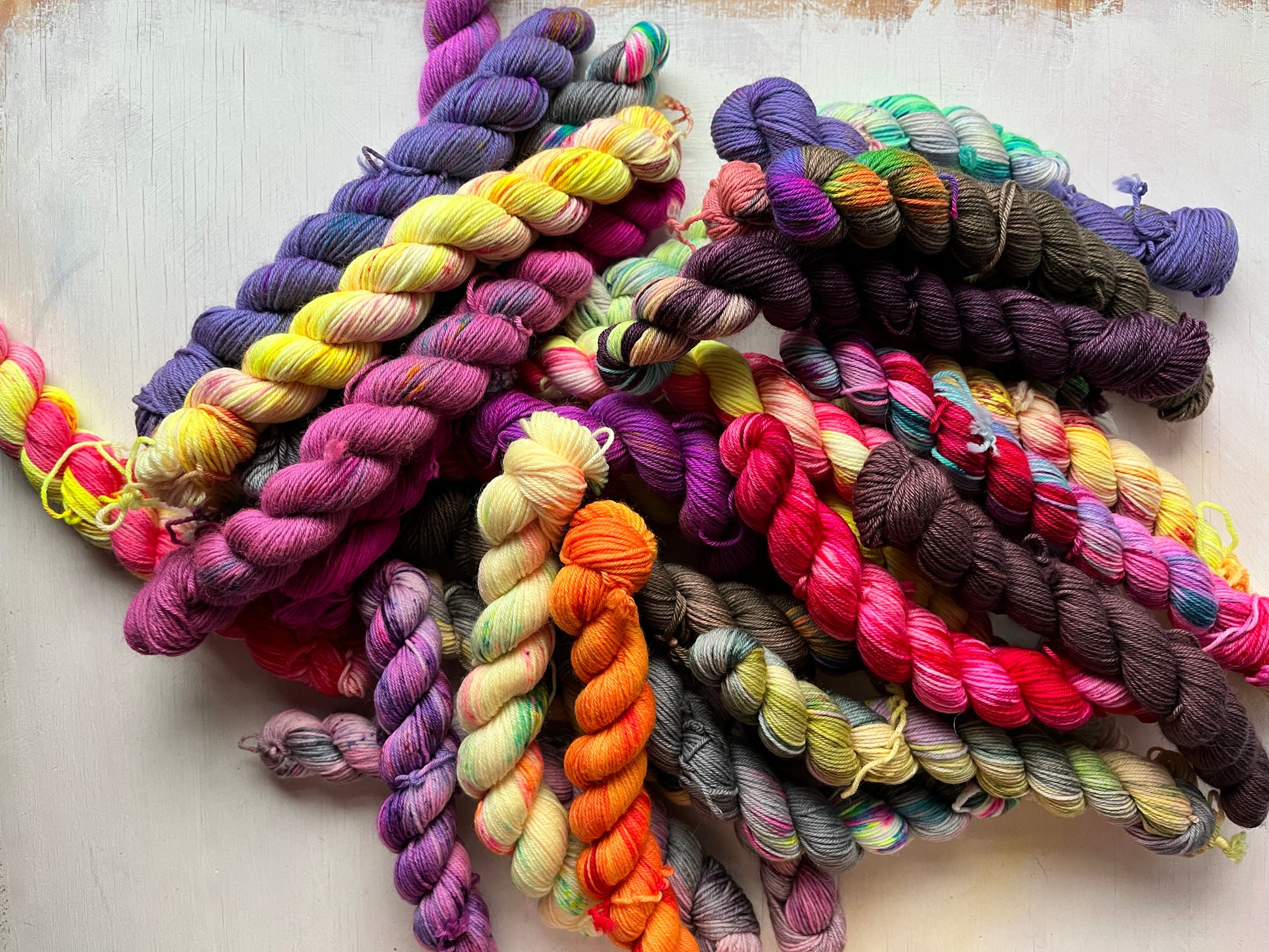 Colorful yarn skeins arranged on a white surface