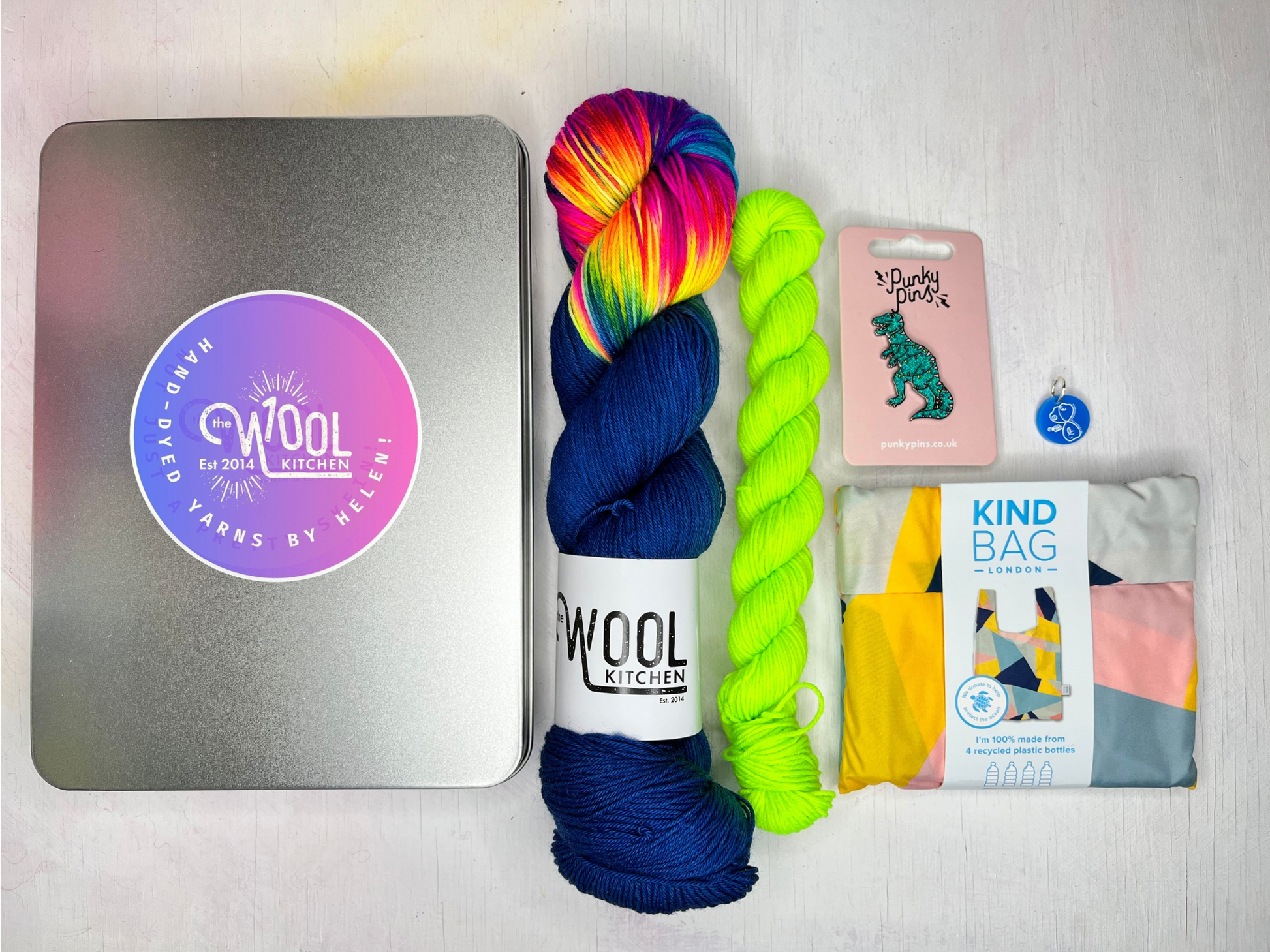 Sock yarn in a tin from the Christmas Gifts collection by the hand dyed yarn expert, The Wool Kitchen. Shown with contrast mini in Neon Lime.